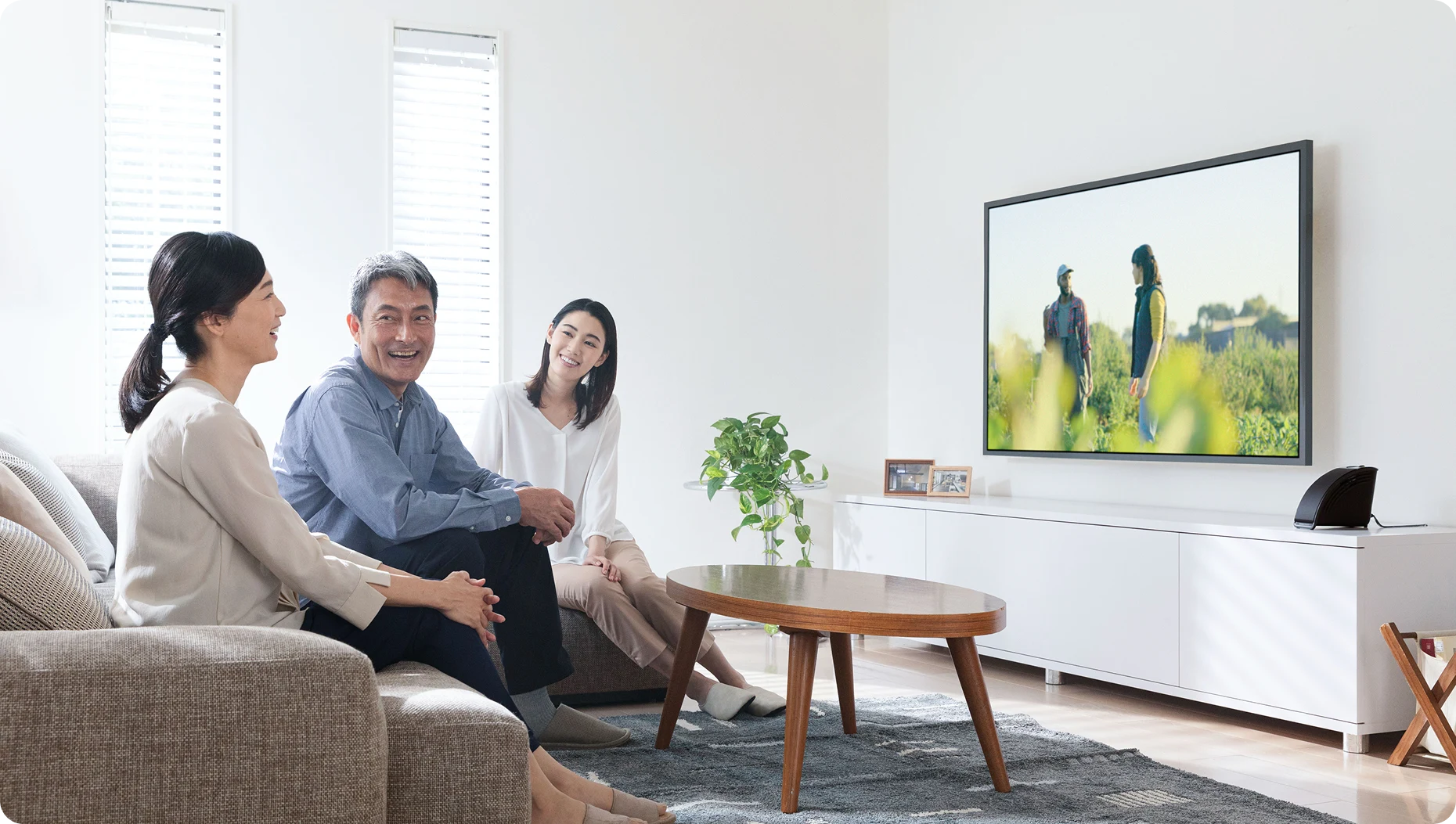 MIRAI SPEAKER Miniを囲んでテレビを楽しむ家族